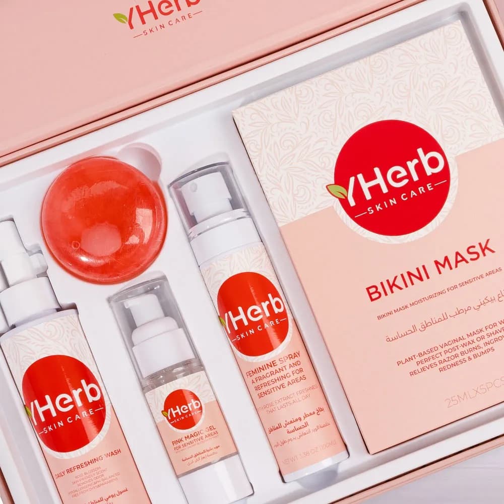 The VHerb Bikini Mask skincare set on a soft pink set with a red sphere